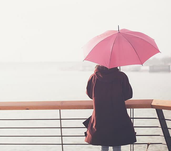 Person carrying a pink umbrella in the rain