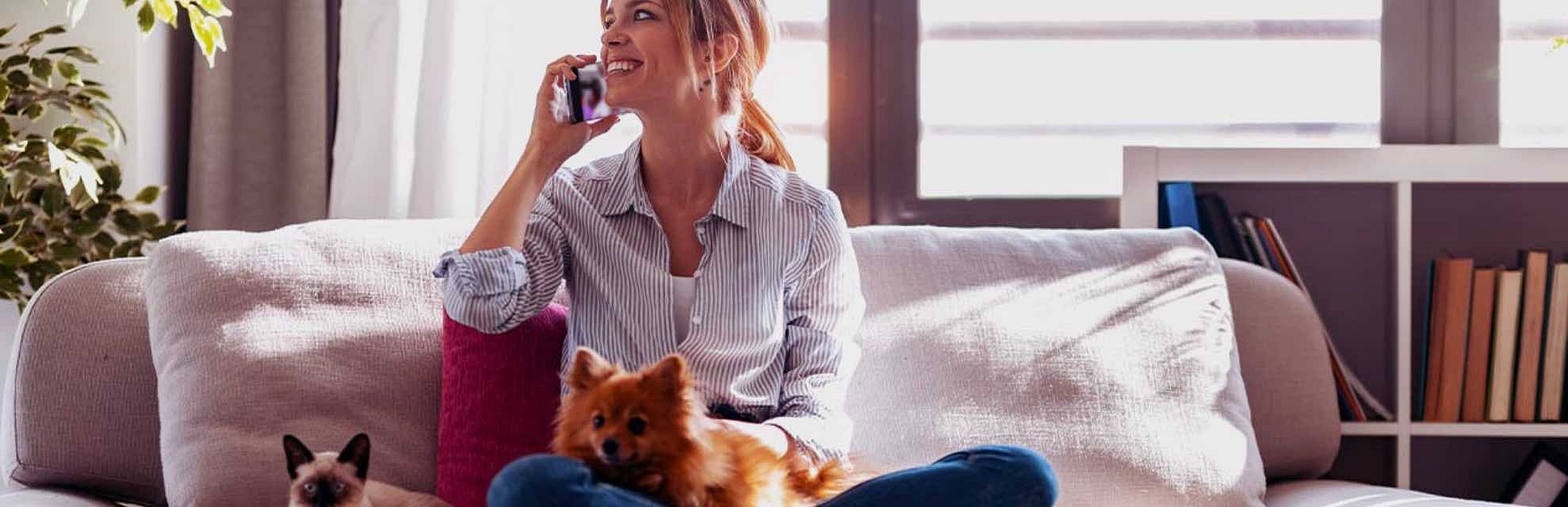Woman sitting on a couch with two pets